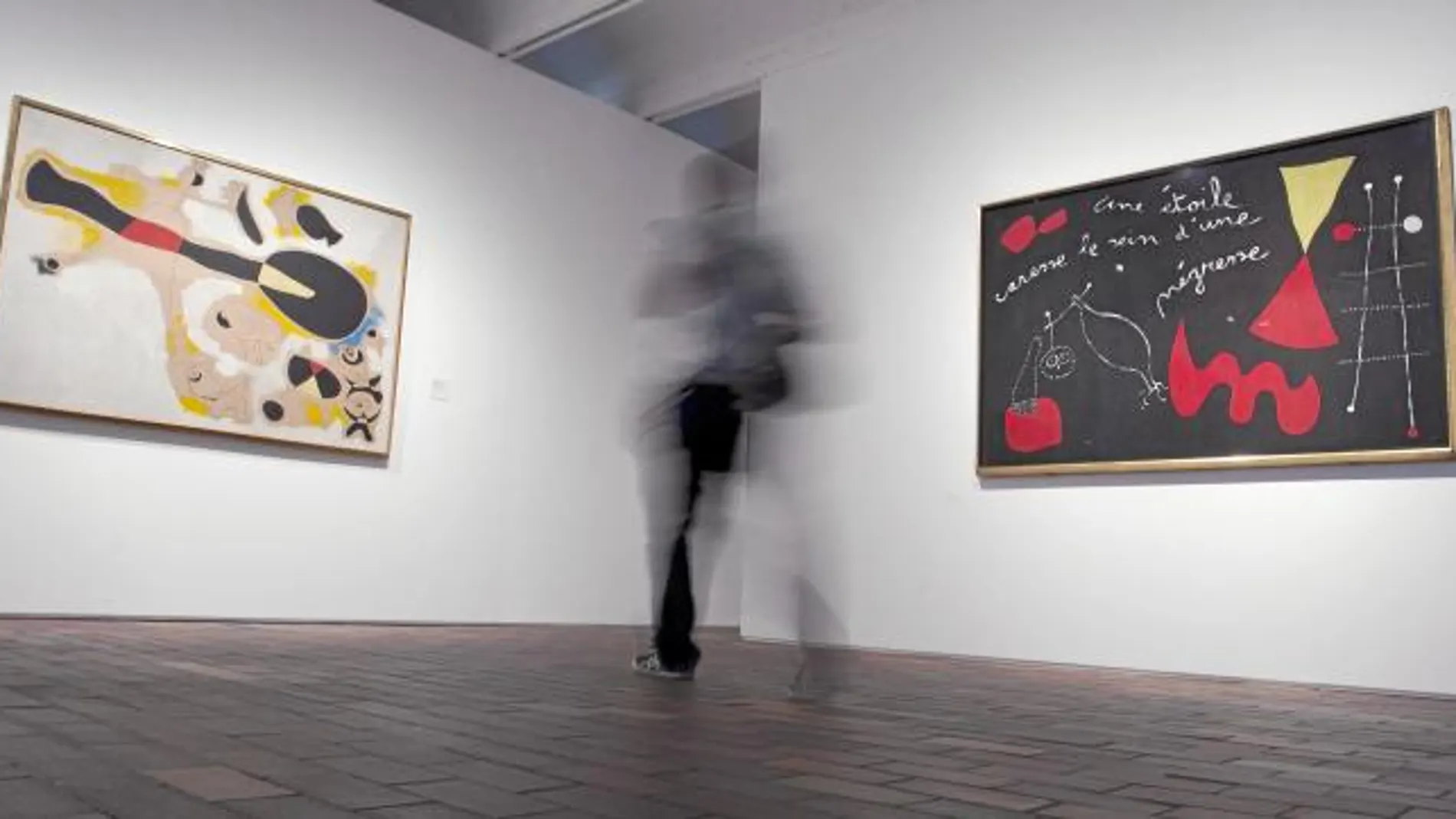 Un visitante contempla dos de los cuadros expuestos en la muestra