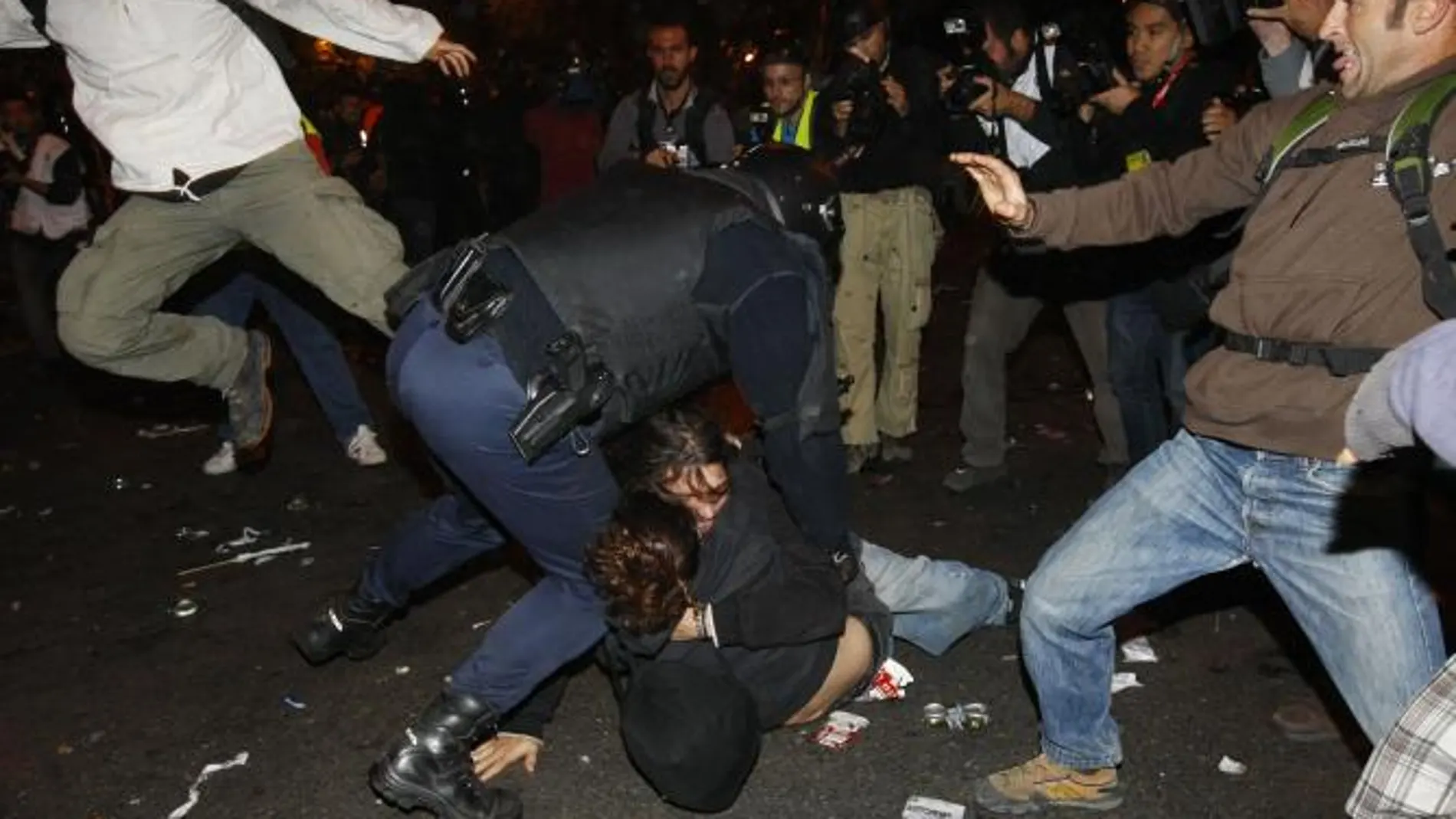 En la imagen, varios jóvenes golpean a un agente de la Policía Nacional