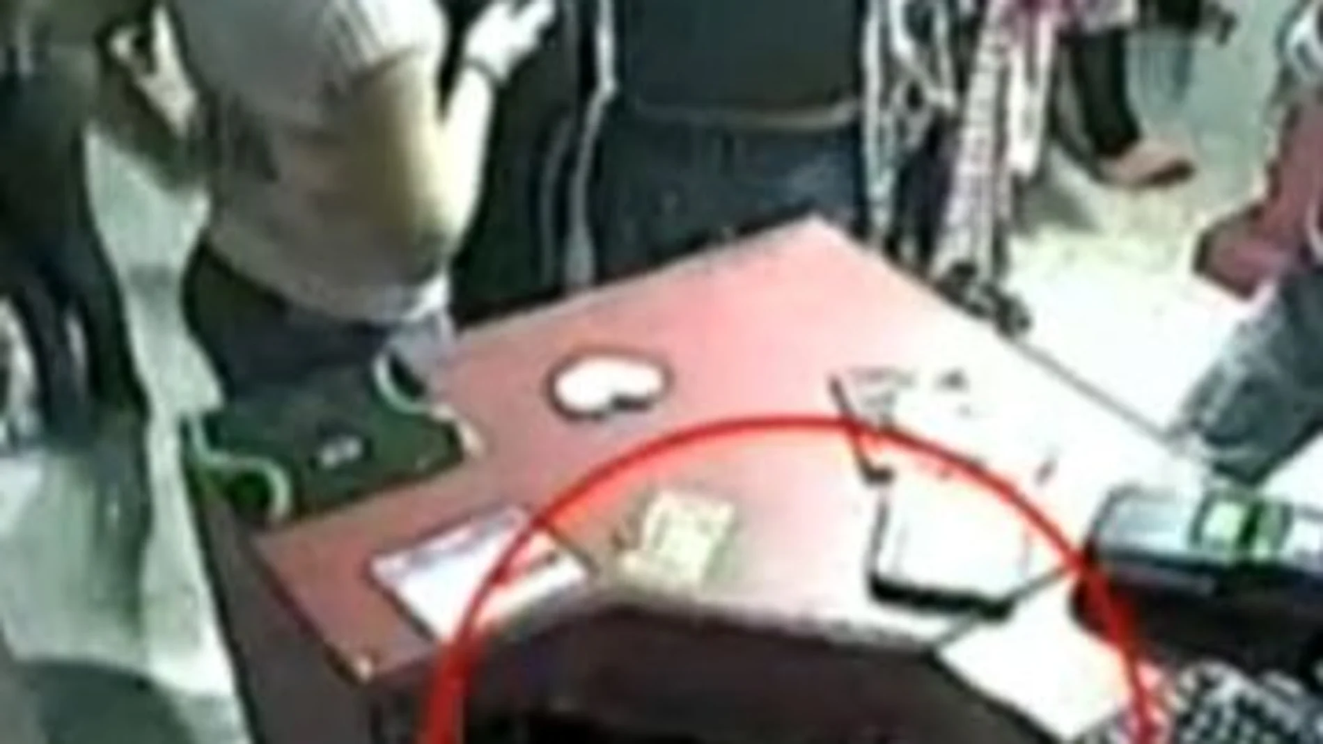 La mano de la niña abriendo la caja, en una imagen de las cámaras de seguridad