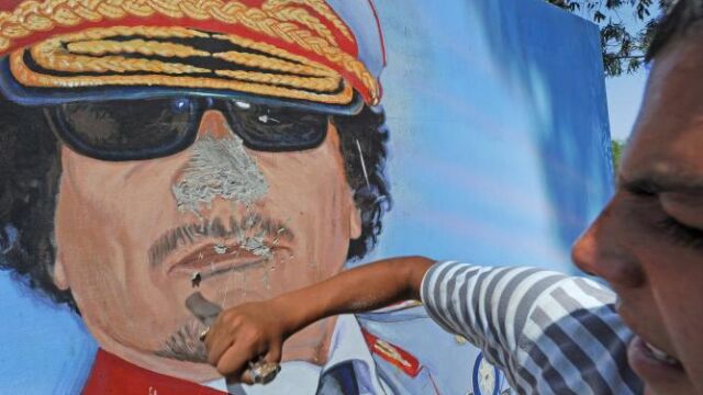 Un hombre destroza un mural en en el cuartel del 32 regimiento Khamis en Trípoli (Libia) después de su saqueo