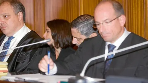 Fernando Mellet, en el centro, baja el rostro ante la presencia de las cámaras en la sala