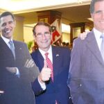 El embajador de EE UU en España, Alan Solomon, posa junto a su mujer, Susan, entre los pósters a tamaño real de los dos candidatos a la presidencia Mitt Romney y Barack Obama.
