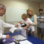 Un niño introduce en la urna la papeleta de su madre en un colegio electoral de Lérida
