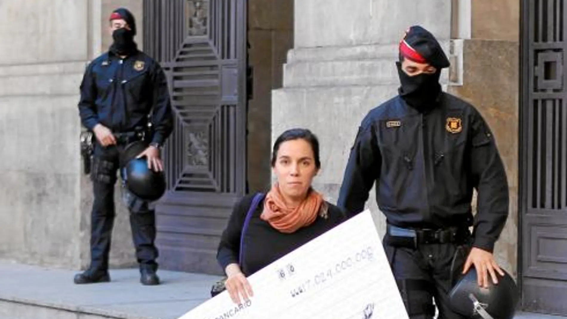 Una activista sale de la sede de CatalunyaCaixa con el cheque