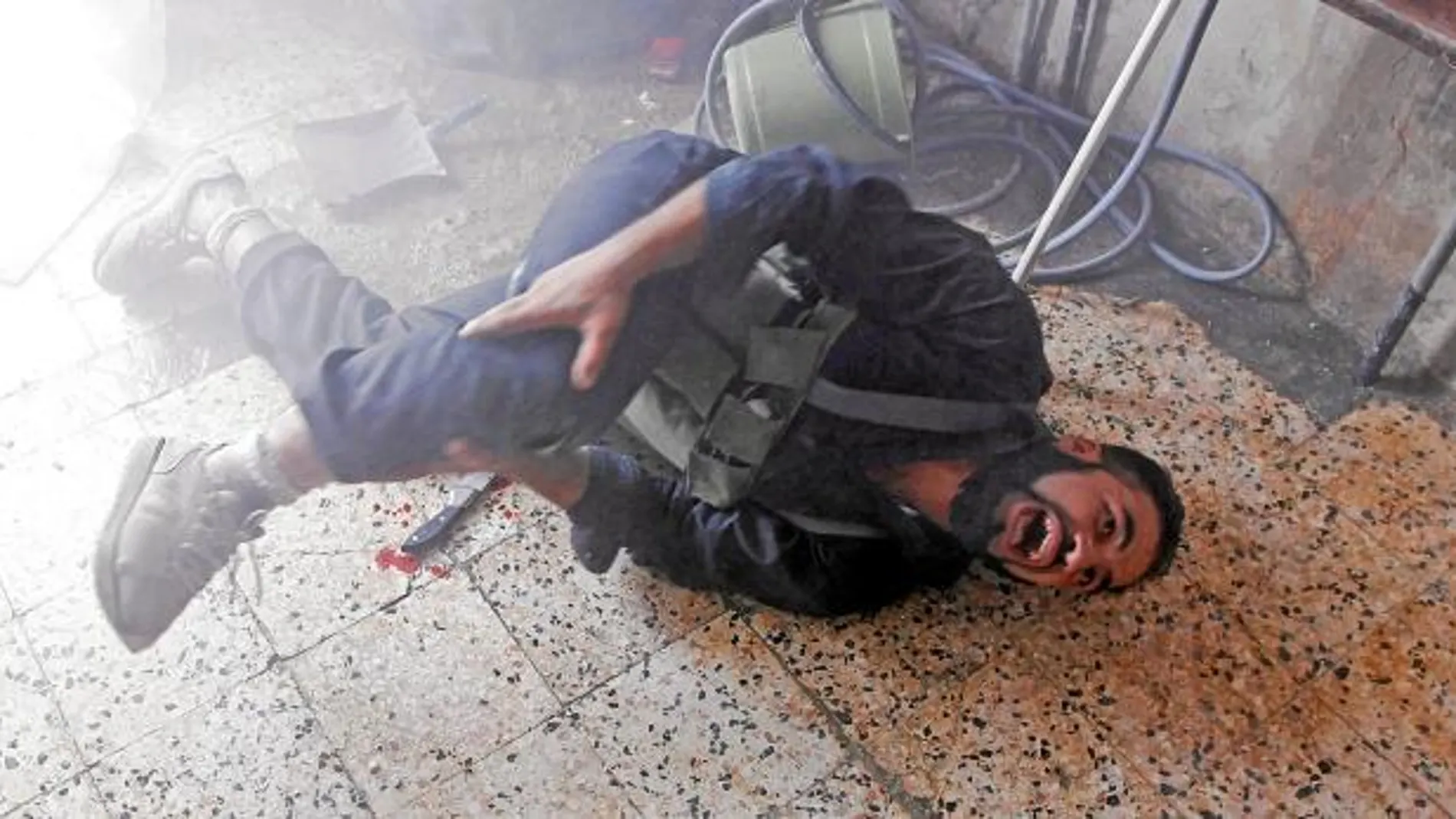 SANGRE Y DOLOR. Un rebelde sirio grita tras ser herido en los combates de ayer en la ciudad de Alepo