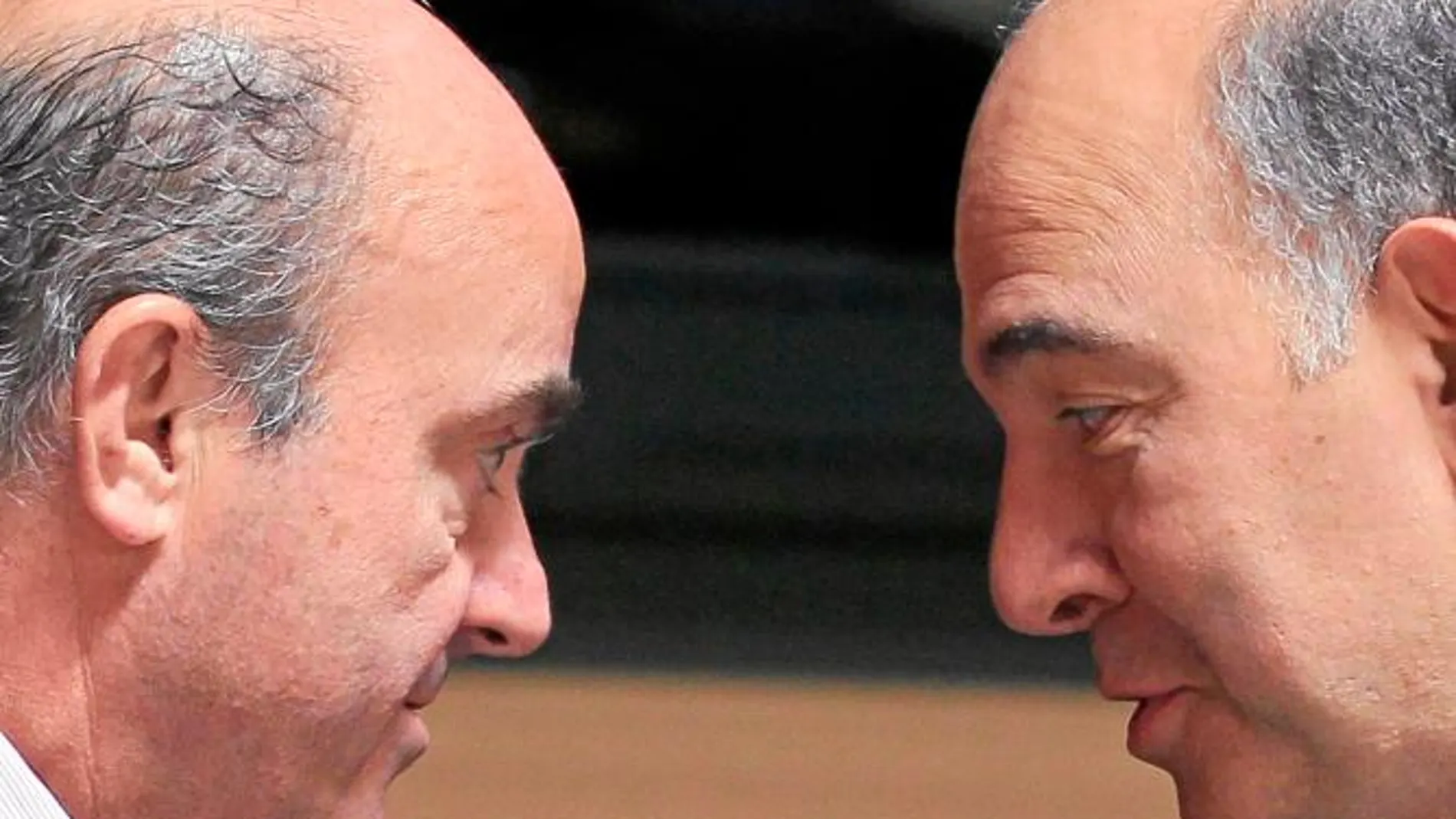 El ministro de Economía español, Luis de Guindos, conversa con su homólogo francés, Pierre Moscovici, durante la reunión en la que España se sumó finalmente a esta iniciativa