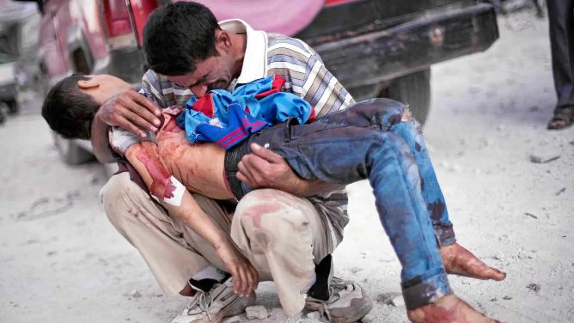 VÍCTIMAS INDEFENSAS. Un hombre llora con el cadáver de su hijo, cerca de un hospital de Alepo, el pasado mes de octubre