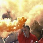 Un manifestante agita una bomba de humo durante una protesta contra las medidas de austeridad en Nápoles