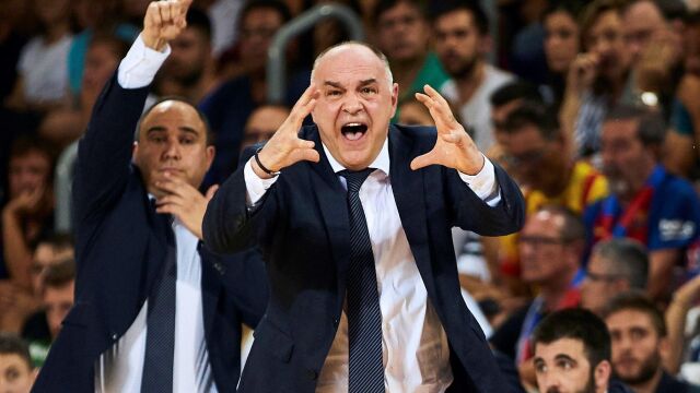 Chus Mateo, detrás de Pablo Laso, da indicaciones en un partido del Real Madrid en el Palau