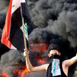 Un manifestante sujeta la bandera de Irak / REUTERS