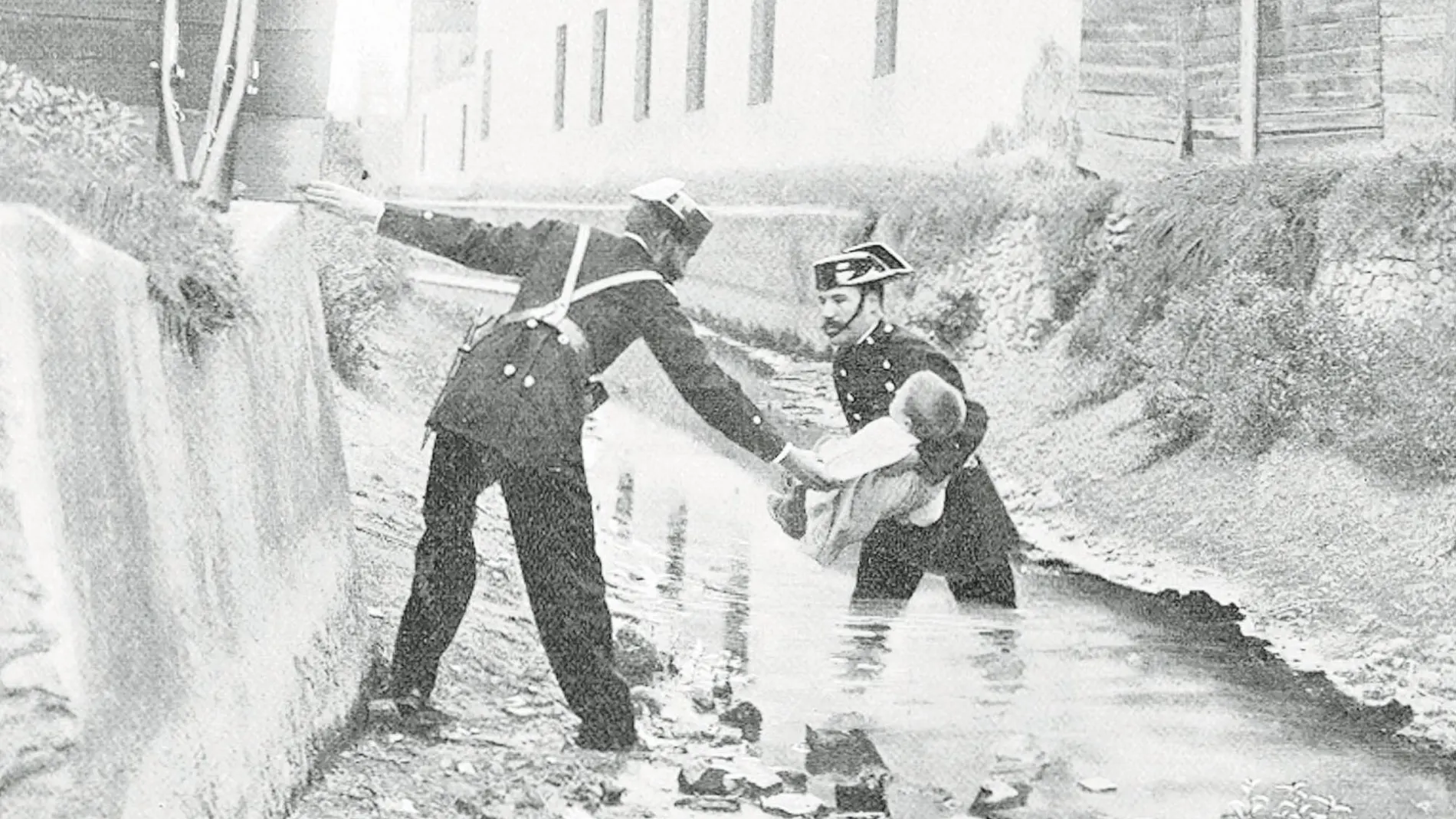 Dos agentes socorren a un niño que quedó atrapado por unas fuertes inundaciones