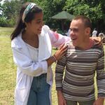 La joven voluntaria Sonsoles Rodríguez acompaña a uno de los enfermos del hospital húngaro, en el que ha trabajado durante quince días este pasado mes de julio