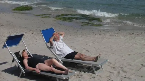 Imagen de archivo de dos personas jubiladas en la playa