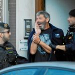 Agentes de la Guardia Civil acompañan a uno de los nueve detenidos entre insultos de grupos independentistas