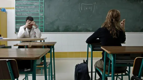 Un profesor y una alumna en un aula de clase