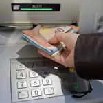 Una mujer saca dinero en un cajero automático
