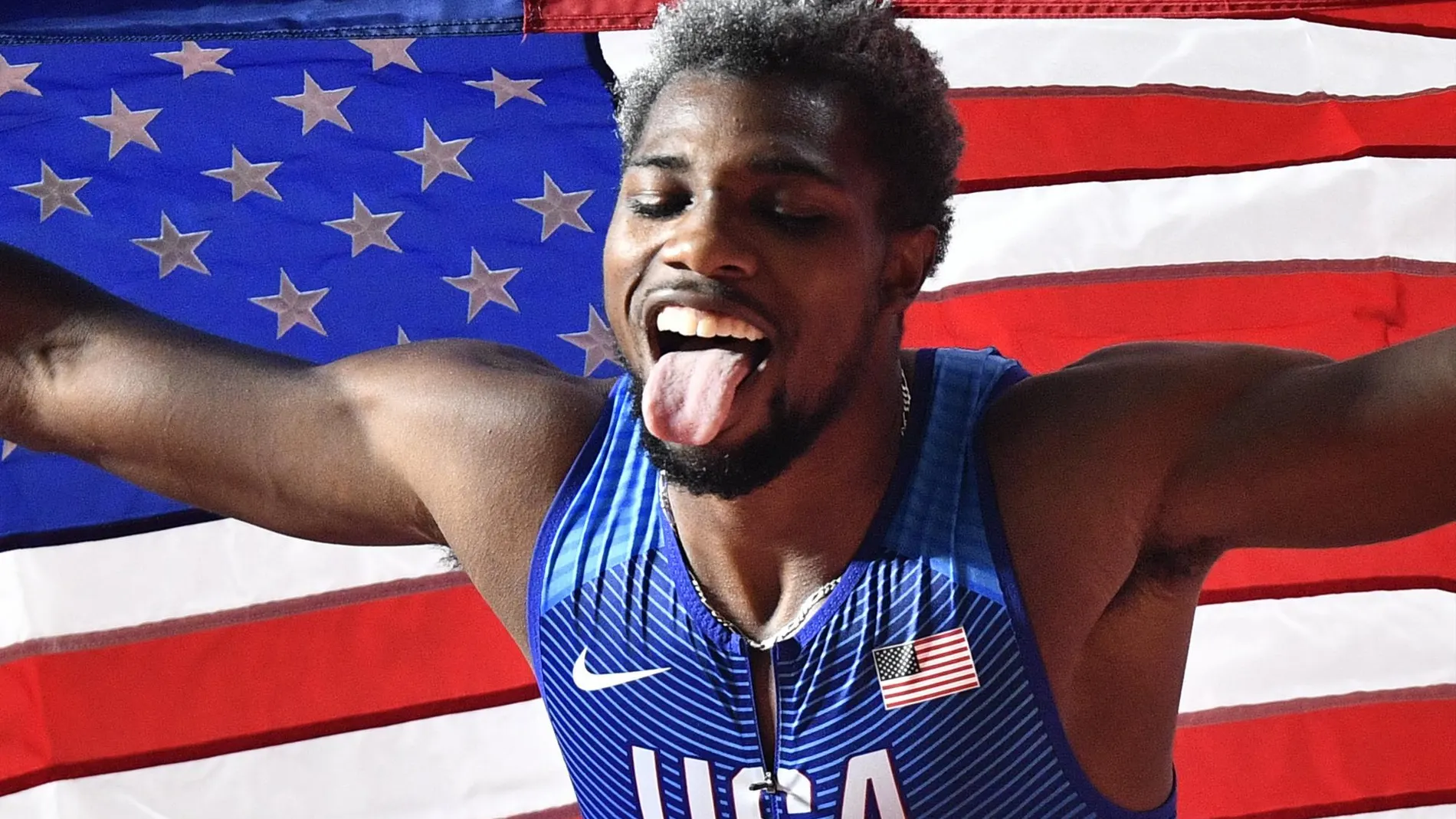 Noah Lyles celebra con la bandera estadounidense su victoria en los 200 en el Mundial de atletismo