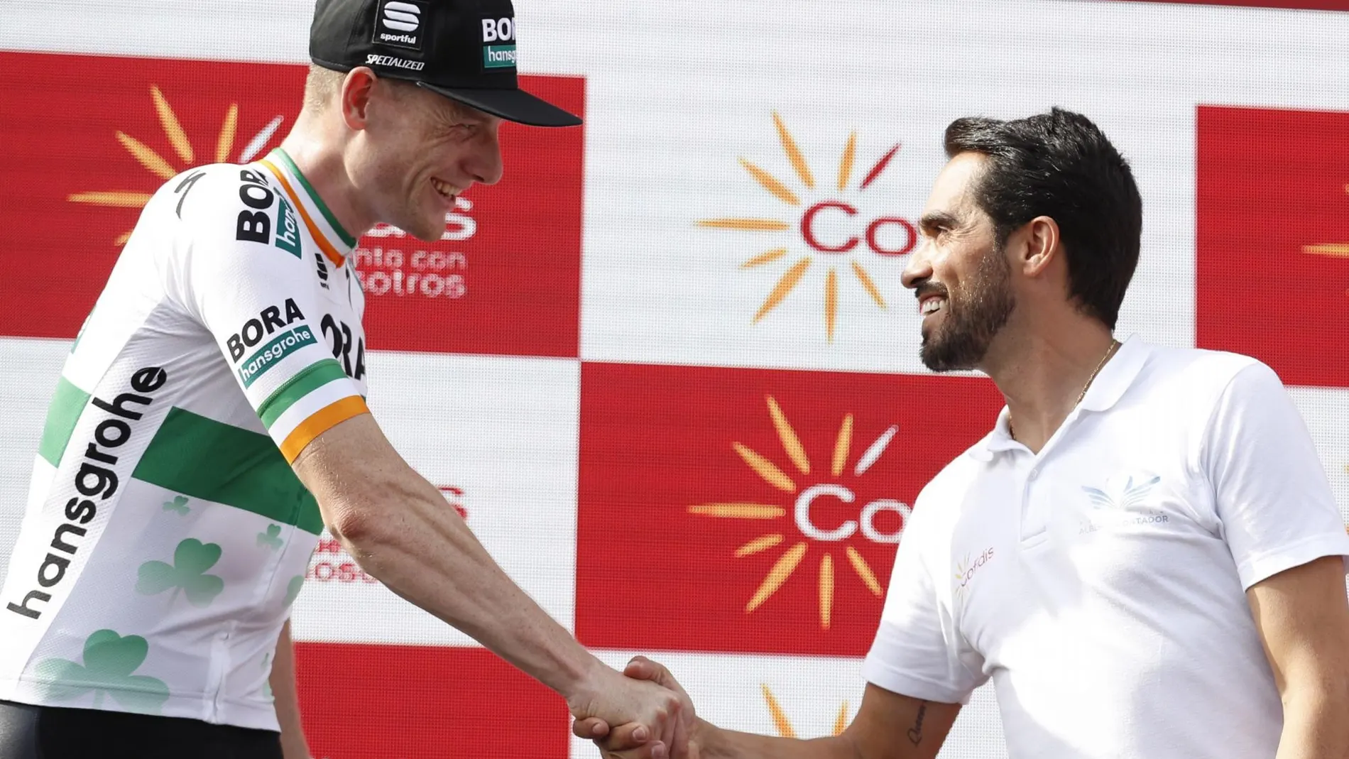Sam Bennett recibe la felicitación de Alberto Contador en el podio