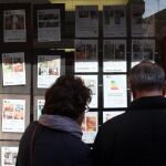 Una pareja mira los anuncios de las viviendas a la venta en una inmobiliaria en Valladolid