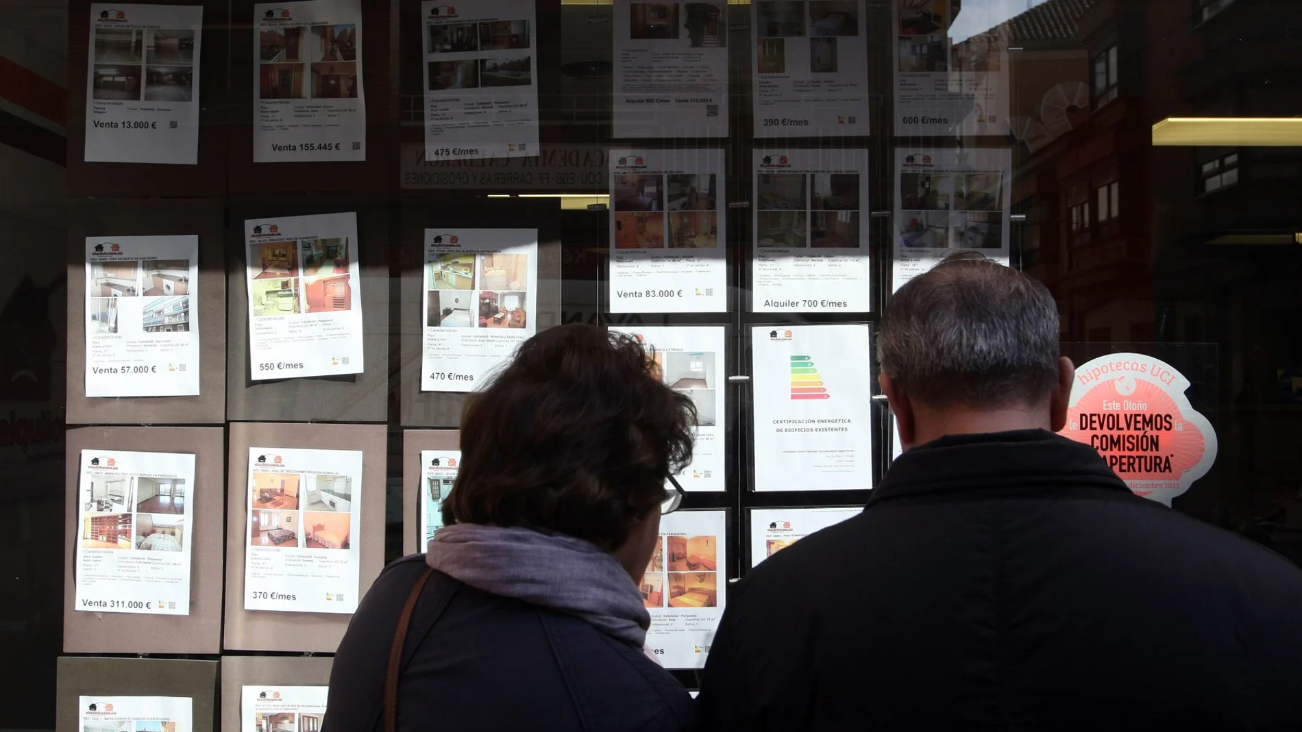 Una pareja mira los anuncios de las viviendas a la venta en una inmobiliaria en Valladolid