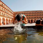 Unos niños se refrescan en una fuente / EFE