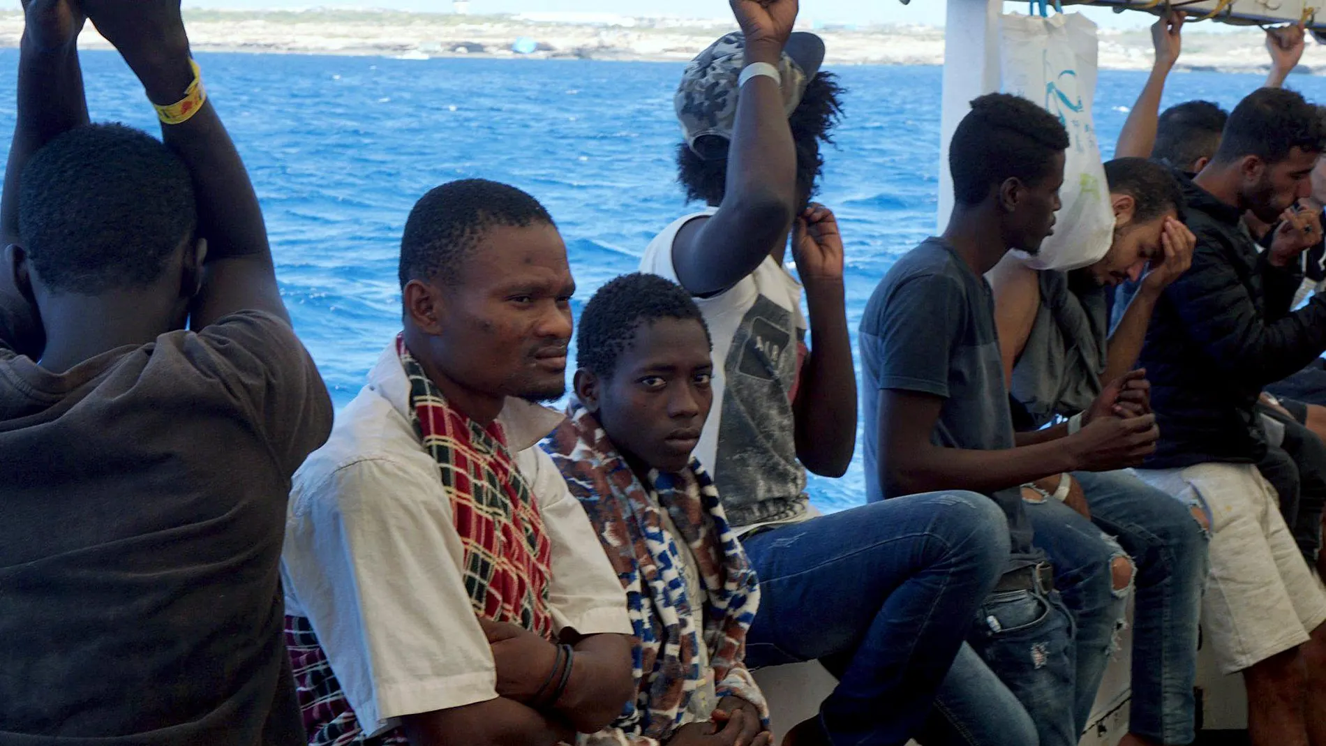 Varios inmigrantes a bordo de la cubierta del "Open Arms"