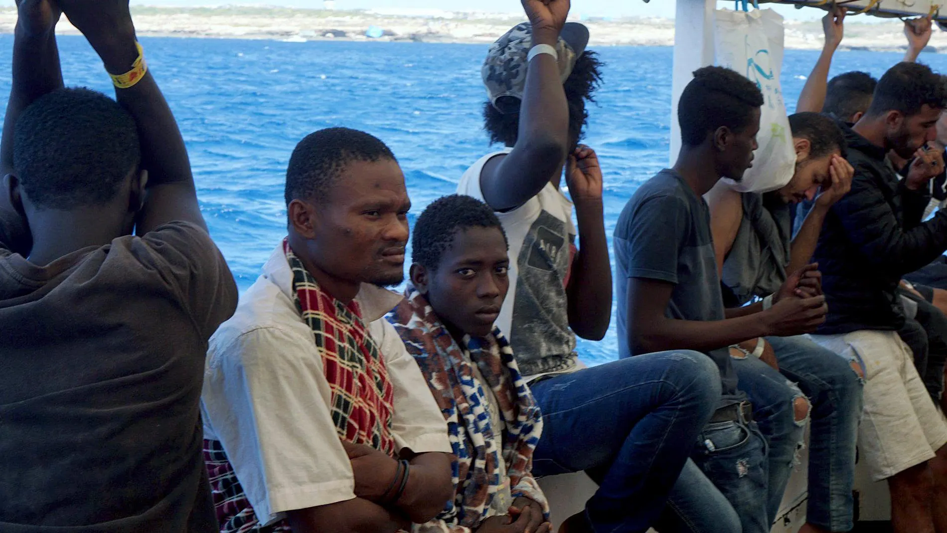 Varios inmigrantes a bordo de la cubierta del Open Arms