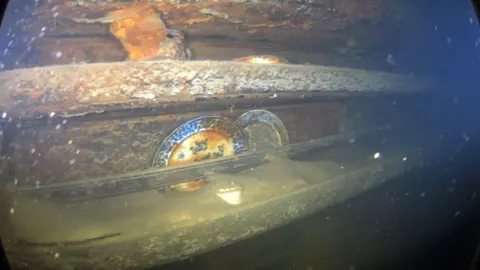 Fotografía cedida por el servicio de Parques de Canadá donde se muestran unos platos y otros artefactos en estantes al lado de una mesa de comedor en el interior del navío HMS Terror