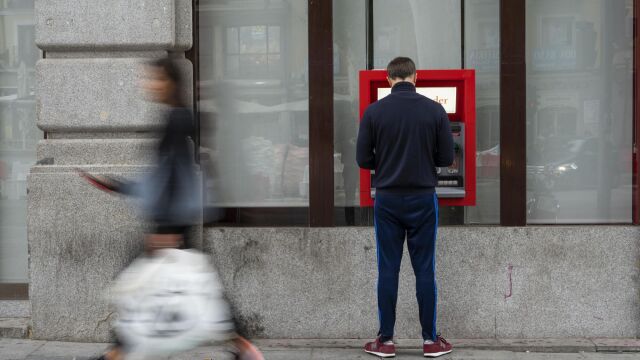 Un hombre saca dinero en un cajero automático