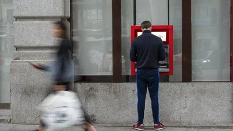 Un hombre saca dinero en un cajero automático