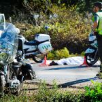 Imagen de la moto siniestrada con el cuerpo sin vida de la víctima detrás y tapado con un sábana