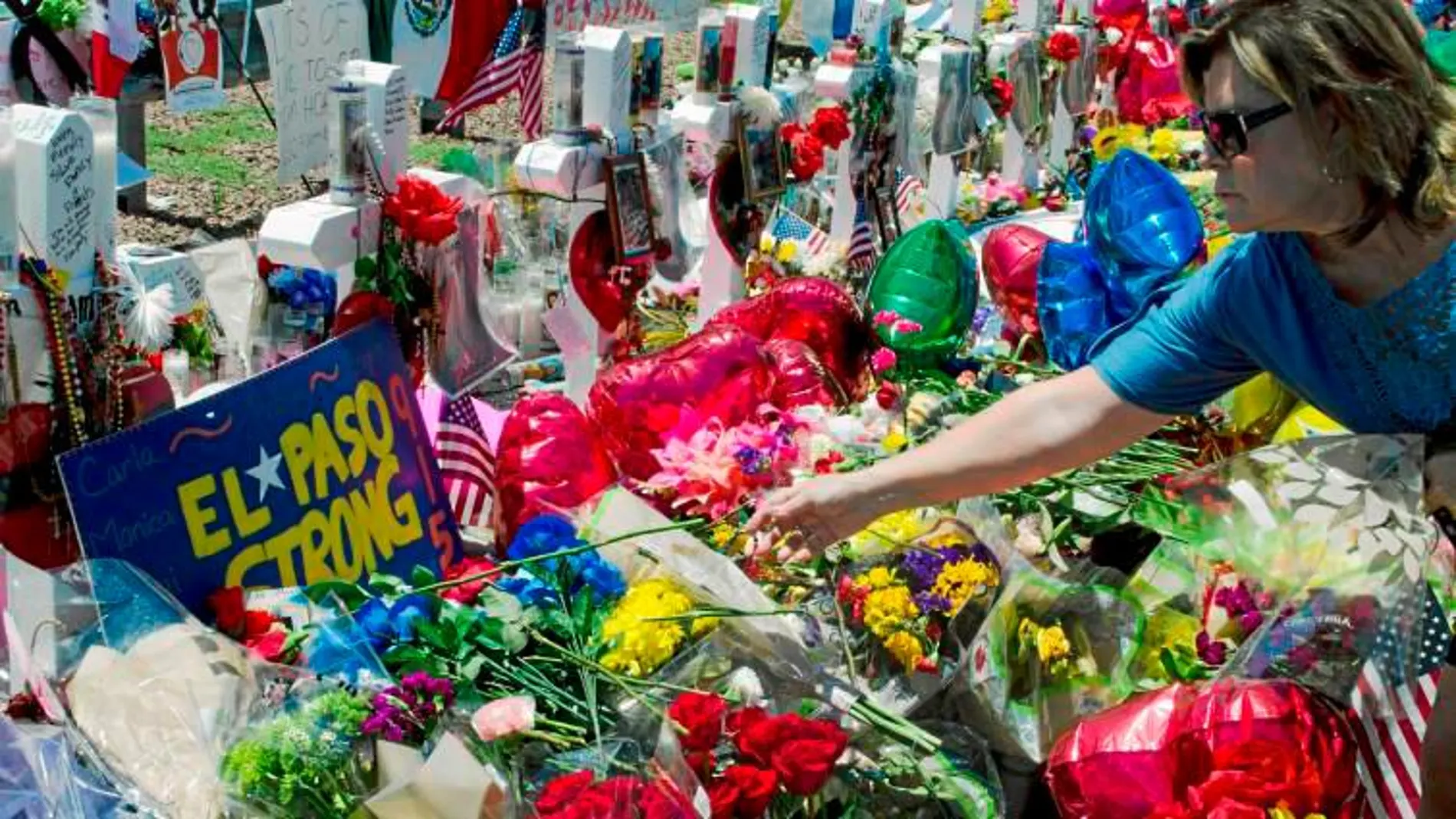 Una mujer deposita una flor en el memorial por las víctimas del ataque terrorista perpetrado por Patrick Crusius