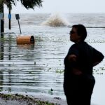 Una mujer junto a una carretera inundada en Lake Pontchartrain, en Luisiana/EFE