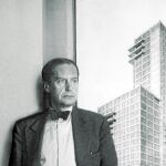 Walter Gropius junto a un póster del edificio de Pan Am en el que colaboró