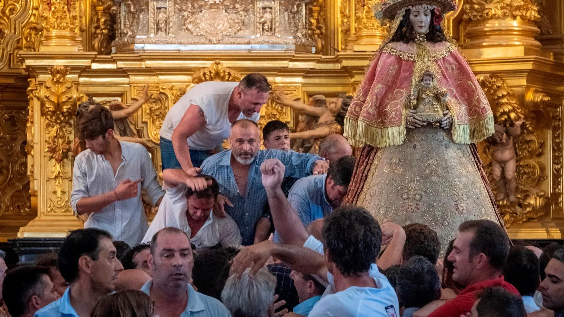 Los almonteños han saltado la reja que separa a la Virgen del Rocío de sus fieles a las 14:47 horas, para comenzar la procesión por las calles de la aldea, previa a su traslado a la parroquia de la Asunción de Almonte (Huelva), la conocida como la Venida, que se celebra cada siete años /Foto: Efe