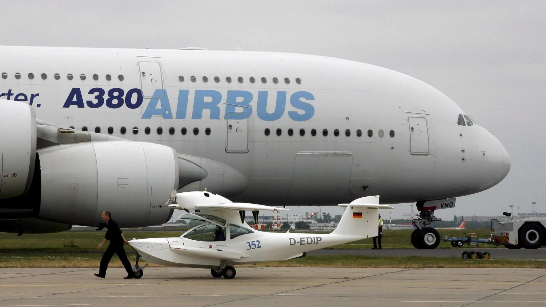 Una avioneta pasa por delante de un Airbus A-380