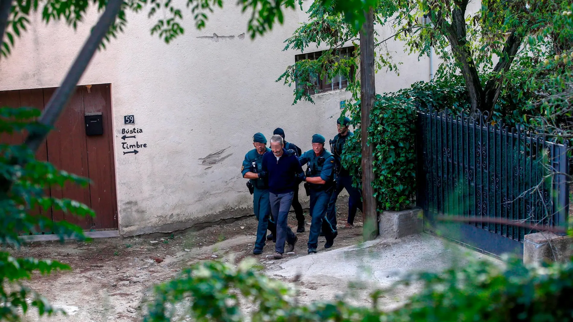 Agentes de la Guardia Civil trasladan a una de las nueve personas detenidas.