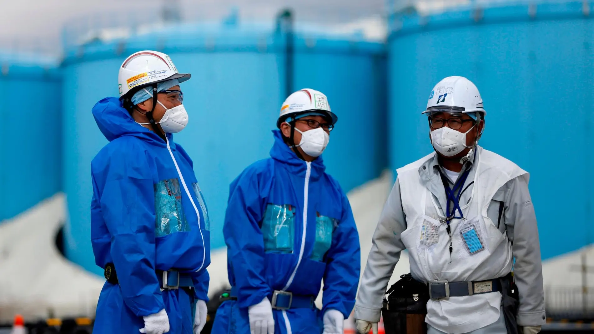Imagen de varios obreros frente a la fábrica de Fukushima