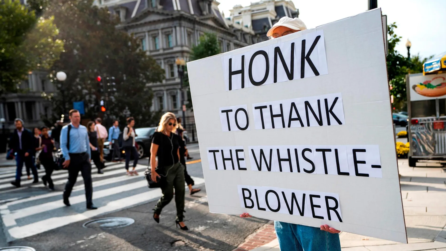 Un hombre da las gracias al “confidente” que ha levantado el escándalo ucraniano en un cartel junto a la Casa Blanca/Efe