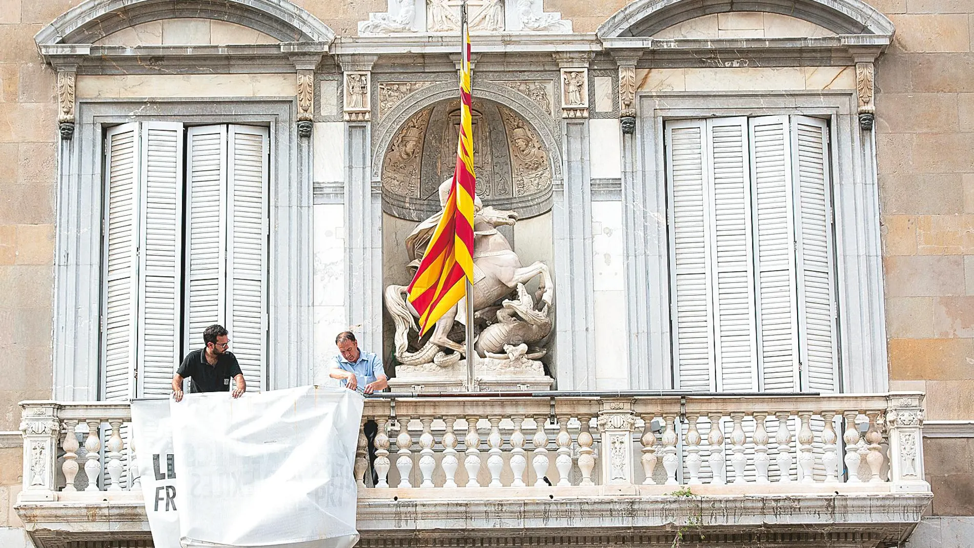 Funcionarios de la Generalitat retiran la pancarta de apoyo a los presos tras la orden del TSJC. Foto: Europapress