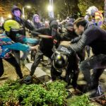Un grupo de manifestantes atacan a un policía durante las violentas protestas de anoche en Barcelona