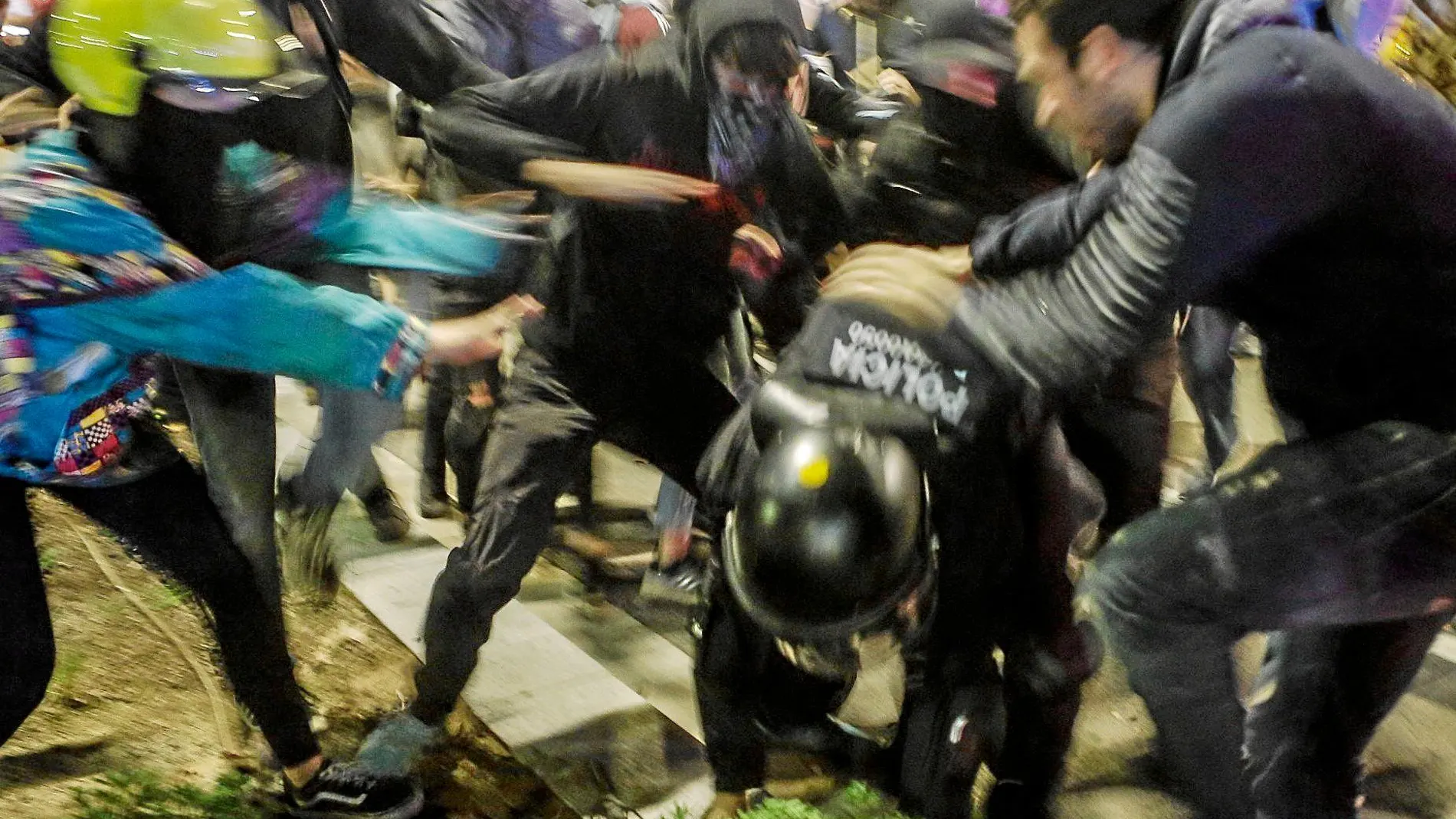 Un grupo de manifestantes atacan a un policía durante las violentas protestas de anoche en Barcelona