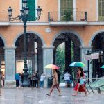 Varias personas se protegen con paraguas de la lluvia en la Plaza Mayor de Palma de Mallorca