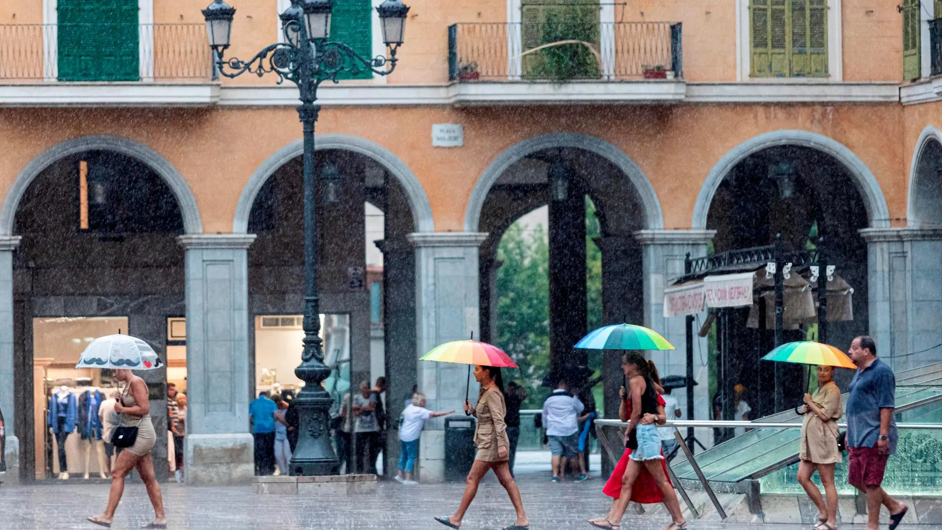 Varias personas se protegen con paraguas de la lluvia en la Plaza Mayor de Palma de Mallorca