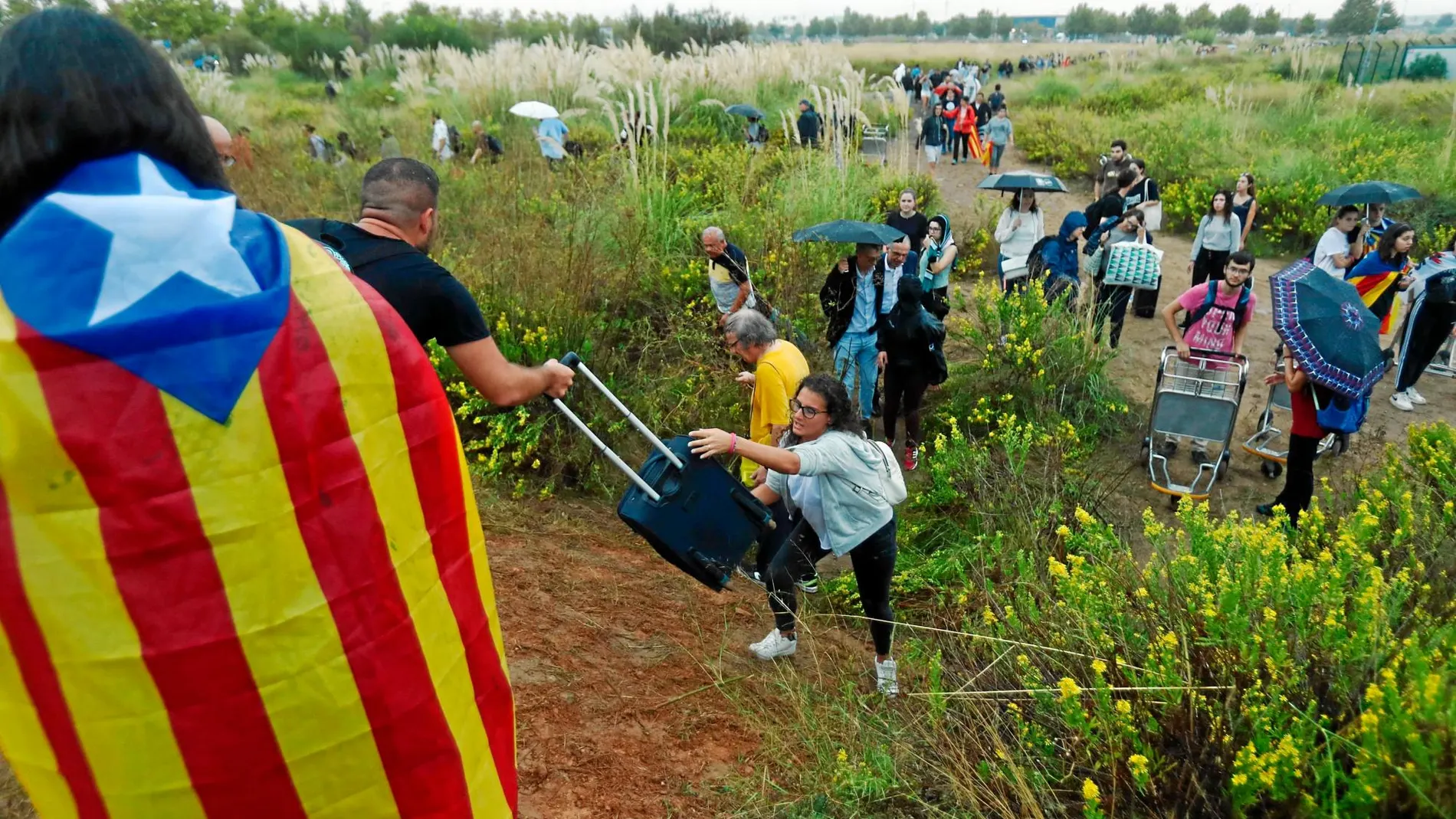 Los turistas arrastran sus maletas ante los cortes de la vías por parte de los manifestantes