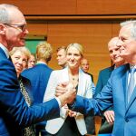 Simon Coveney, ministro de Exteriores de Irlanda (izquierda), saluda al negociador jefe de la UE para el Brexit, Michel Barnier, ayer en Luxemburgo
