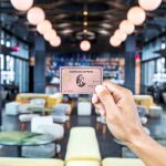 Un consumidor muestra la nueva Gold Card de American Express