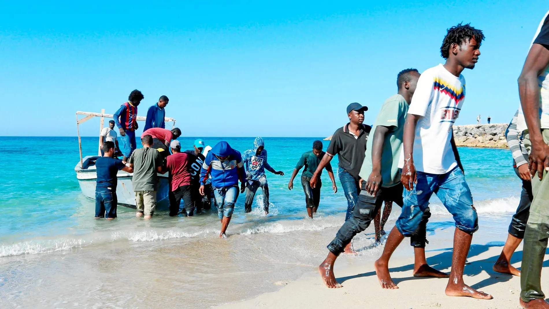 Migrantes en la costa libia tras haber sido rescatados por los guardacostas italianos