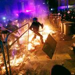 Los Mossos d’Esquadra se vieron obligados a cargar contra los manifestantes en varias ocasiones. Más de 20 hogueras ardían anoche en Barcelona, como este fuego que atraviesan los agentes. Foto: Reuters