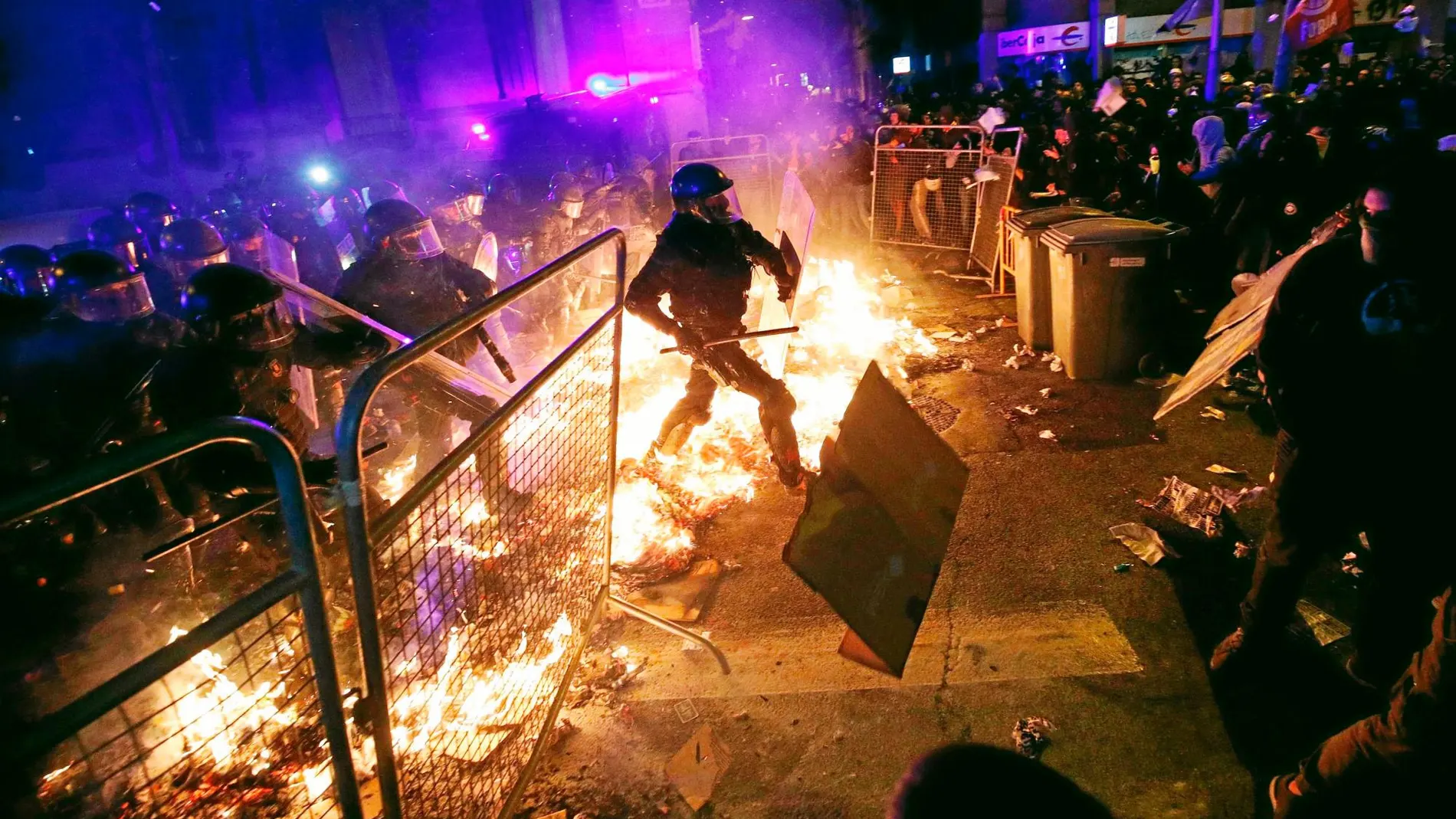 Los Mossos d’Esquadra se vieron obligados a cargar contra los manifestantes en varias ocasiones. Más de 20 hogueras ardían anoche en Barcelona, como este fuego que atraviesan los agentes. Foto: Reuters
